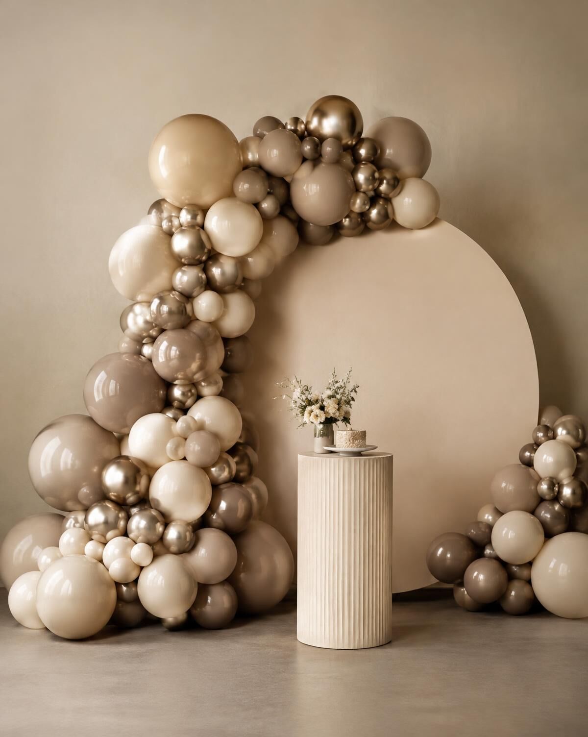 Organic balloon garland in cream, taupe and champagne around a round backdrop