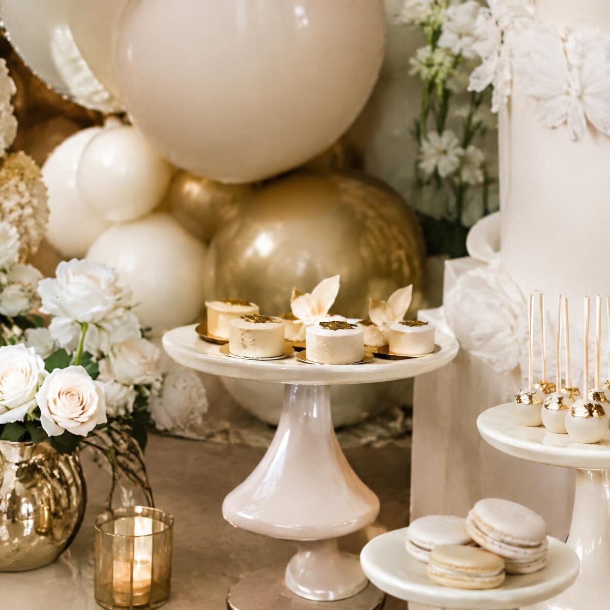 Ivory dessert display with gold-leaf pastries, cream balloons and white roses